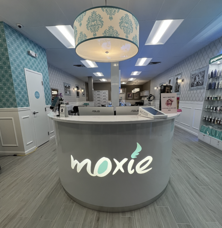 Moxie salon front desk with illuminated logo